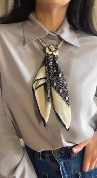 Джинсы с блузкой под воротником которой жемчужное ожерелье с платком